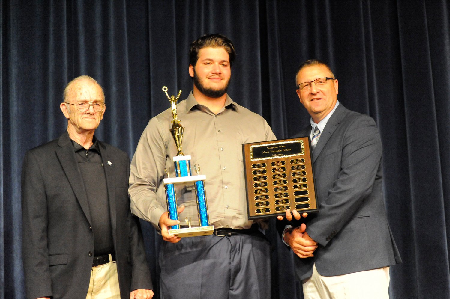 Christopher Campanelli, Sullivan West’s 2021-2022 Most Valuable Senior Male Athlete is flanked by his coaches, Ron Bauer (speaker) and John Meyer (presenter)...